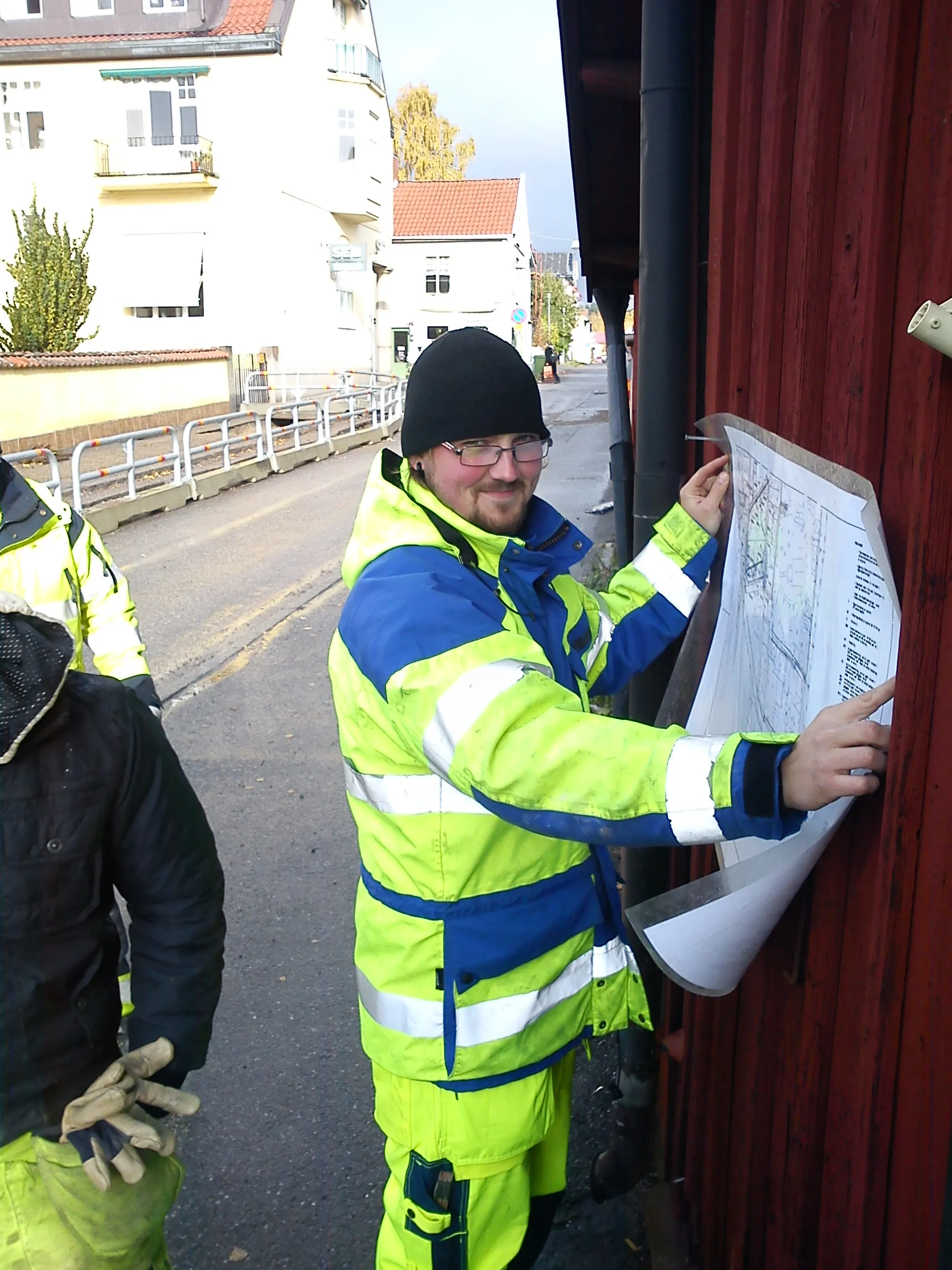 Medarbetare i varselkläder går igenom en ritning