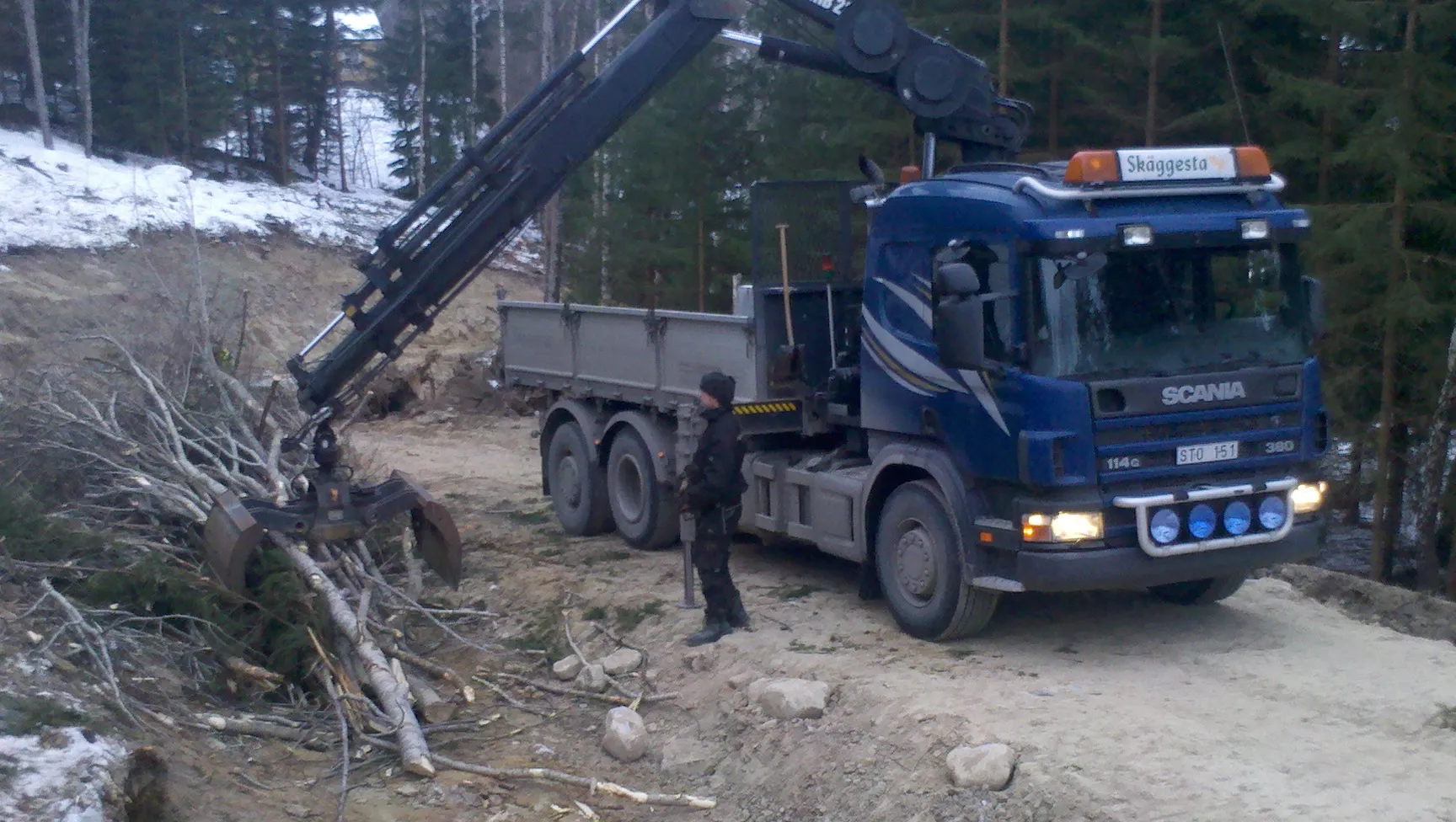 Scania-lastbil med kran vid ett uppdrag i skogen